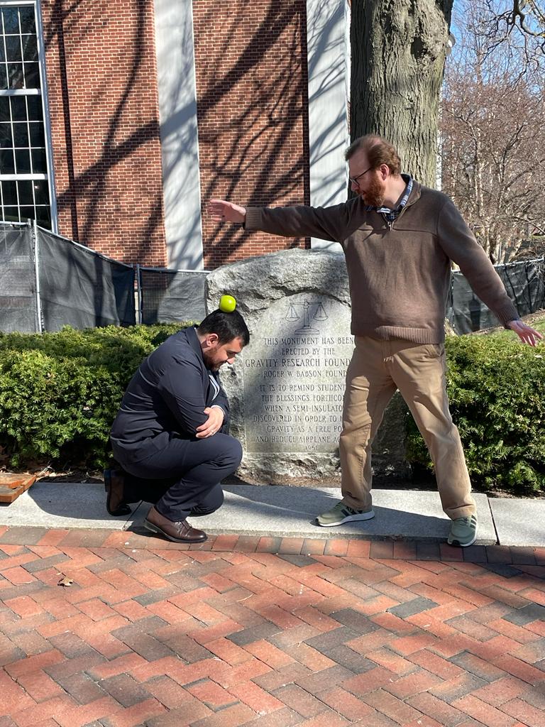 After the successful dissertation defense of cosmology graduate students at Tufts, an apple is dropped by the advisor on the student's head so that they may be inspired as Isaac Newton was.